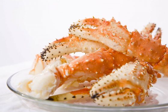 A pile of fresh crab legs on a white background.